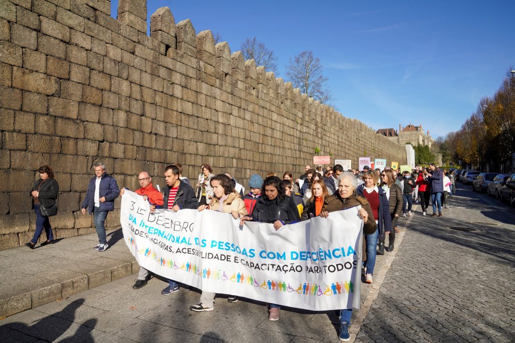 Caminhada inclusiva a descer a rua da muralha, em Guimarães